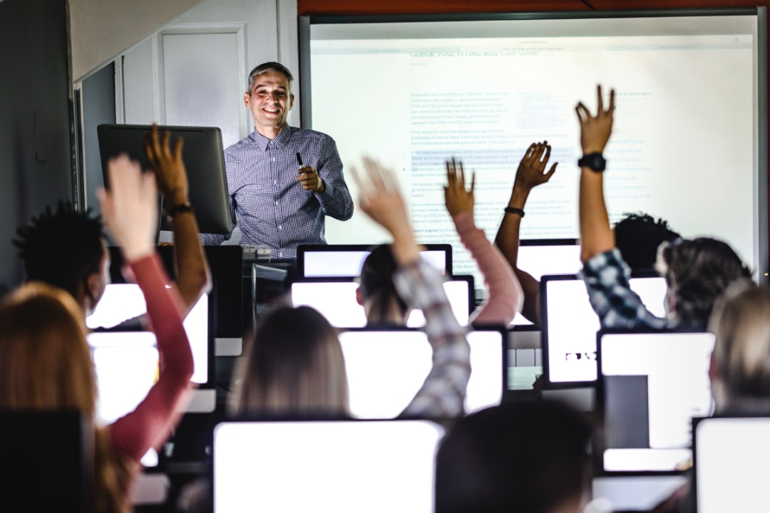 teacher teaching students on comptuers